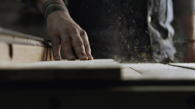 carpenter work with machine circular saw. electric saw machine blade and board in a wood shop. workers sawing boards with a circular saw