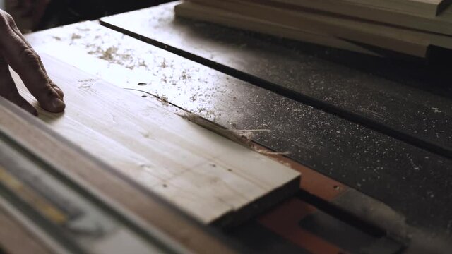 carpenter work with machine circular saw. electric saw machine blade and board in a wood shop. workers sawing boards with a circular saw