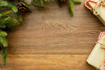 Beautiful Christmas background with two gift boxes, decorate with pine branch and pine cone over wood background. Top view with copy space, flat lay.