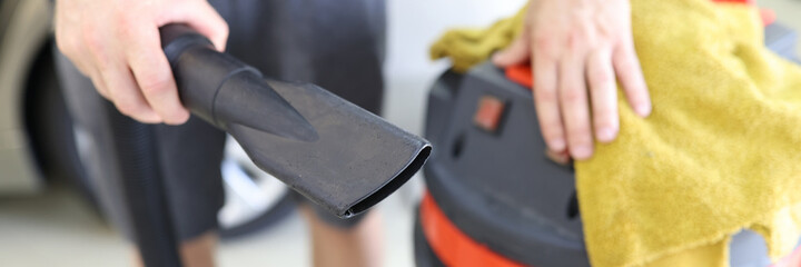 Man cleaner holding pipe from professional vacuum cleaner and microfiber cloth closeup