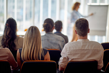 A group of young business people attends a business lecture in the conference room. Business,...