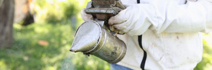 Beekeeper holding smoker for smoking bees closeup