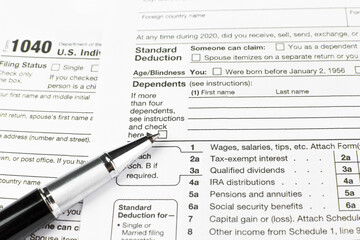 Close-up of a black pen placed on a 1040 US personal income tax form..