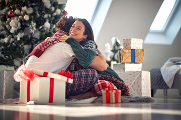 Obraz na płótnie Canvas Embracing couple for Christmas.Girl surprise her boyfriend
