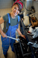 Happy girl mechanic working in the workshop