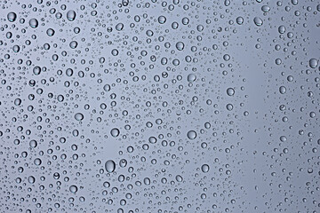 gray wet background / raindrops to overlay on the window, weather, background drops of water rain on the glass transparent