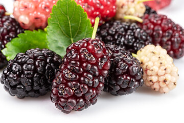 Ripe black mulberries fruits with green leaves isolated on white background.