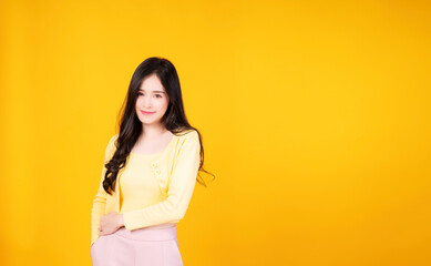 Fototapeta na wymiar Confident charming Asian young woman wear hipster style standing over isolated yellow background. Cheerful student or businesswoman smart success while looking at camera.