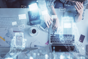 Double exposure of man and woman working together and the envelop hologram drawing. Computer background. Top View. Electronic mail concept.
