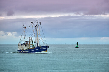 Ein Krabbenkutter ( CUX 9 RAMONA ) neben der Kugelbake an der Elbmündung in Cuxhaven.