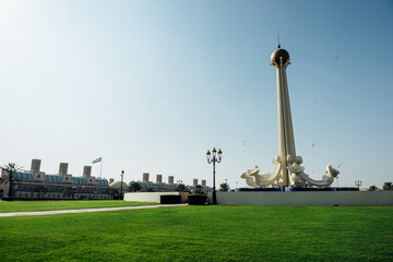 Etihad Park - a landmark area n Sharjah, UAE. View of a, Etihad tower standing in a lush green lawn.