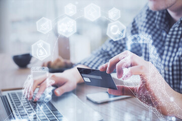 Double exposure of man hands holding a credit card and tech theme drawing. Technology in E-commerce concept.
