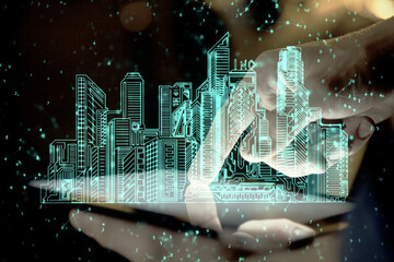 Double exposure of man's hands holding and using a digital device and city drawing.