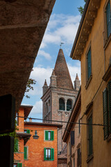 Colored facades of old buildings with balconies decorated with plants in the old part of Verona. Traditional Italian buildings