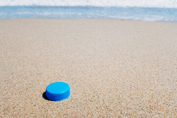 Plastic plug on the clean sand of a beach.