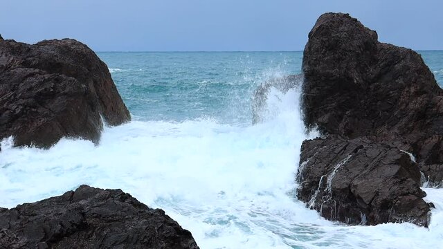 日本海の荒波　岩場　激しい波しぶき