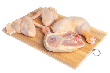 A chicken carcass cut into pieces on a cutting board, isolate on a white background. Legs, thighs, chicken wings on a chopping board