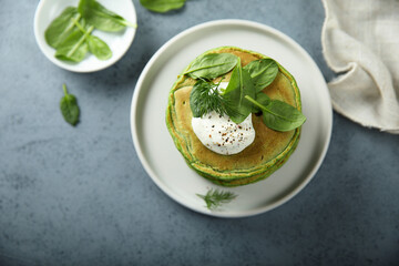 Traditional homemade spinach pancakes with sour cream
