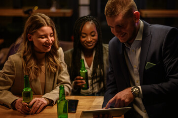 Cheerful colleagues drinking beer in the bar together after work