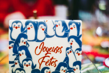 Plaque décorative sur un gâteau avec des pingouins et texte Joyeuses Fêtes