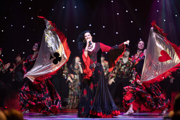 A team of musicians, singers and dancers in gypsy costumes singing and dancing on stage