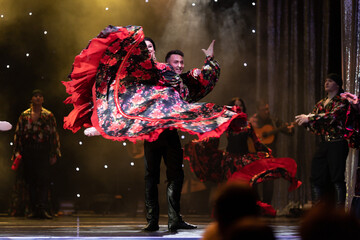 A team of musicians, singers and dancers in gypsy costumes singing and dancing on stage