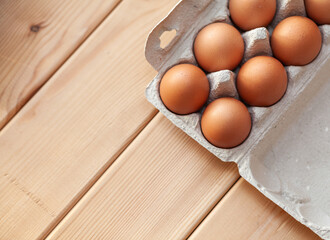 Few brown eggs among the cells of a large cardboard bag, chicken egg as a valuable nutritious product, a tray for carrying and storing fragile eggs. Not a full package of eggs, an important food item