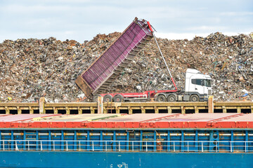 The harbour of Newhaven, UK, with lorry delivering scrap metal to the dock yard, ready for loading and shipping out of the country.