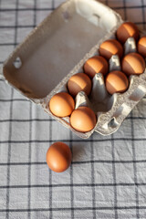 Few brown eggs among the cells of a large cardboard bag, chicken egg as a valuable nutritious...