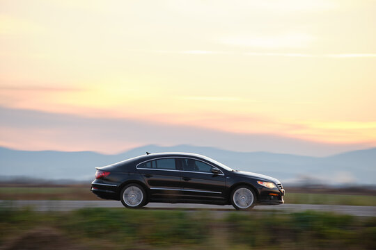 Car driving fast on intercity road at sunset. Kyiv, Ukraine - October 12, 2021.