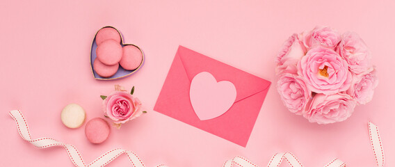 Flowers roses, gift box and sweets macaroons on pink background. Valentines day concept. Flat lay,...