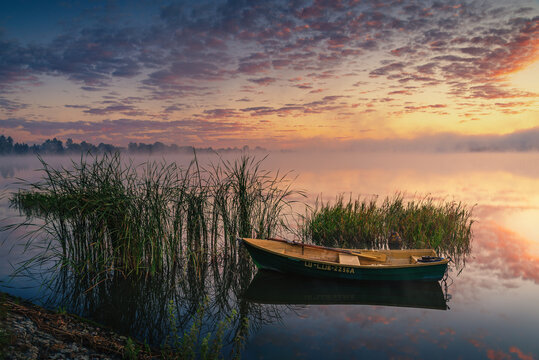 Boat on the lake in the rays of the rising sun and fog, zemborzycki lake © RafalDlugosz