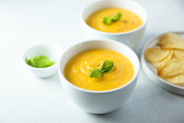 Traditional homemade pumpkin soup with fresh basil