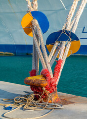 Ship mooring rope on the port wharf. Harbor bollard for large naval. Season of the summer.