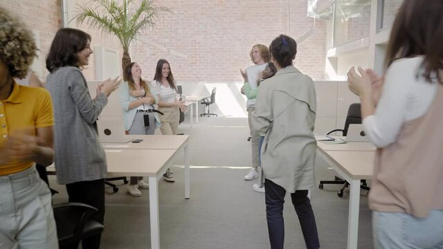 Business team enjoying success in modern office. Multiracial happy coworkers celebrating good news, moving, smiling, raising hands up. Concept of people, victory, work.