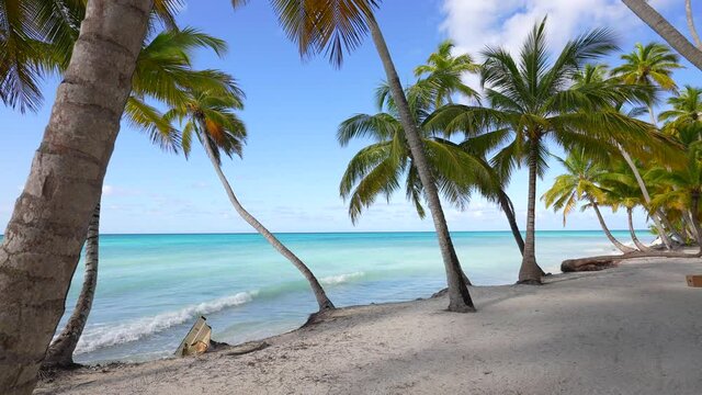 Panama, San Blas Islands - Shot of a Sailing Yacht anchored in Turquoise Water right next to perfect White Sand Beach of remote Tropical Island full of green Palm Trees in Caribbean Sea.