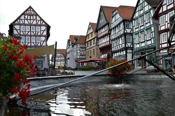 Naklejka premium Wasser im Marktbrunnen mit Fachwerkhäusern am Marktplatz in Fritzlar