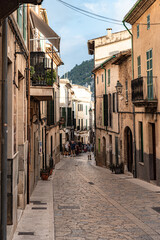 Fototapeta na wymiar Street with old buildings clear sky and greenery on an island in Spain, Mallorca, Alcudia