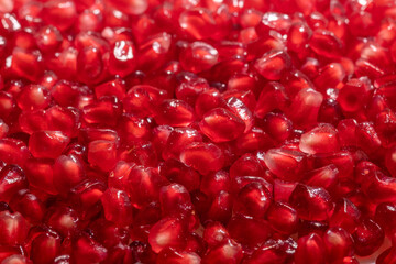 peeled red pomegranate seeds scattered background