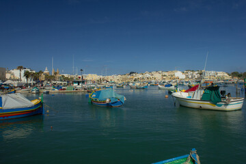 Port town with old buildings and waterfront in late summer in Malta, Marsaxlokk