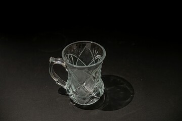 small oriental style glass tea cup with engraving isolated on dark background