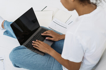 Fototapeta na wymiar Young afro american woman working on laptop with blank screen