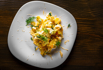 Potato salad with onions and cucumber, mayonnaise-cream dressing in white plate
