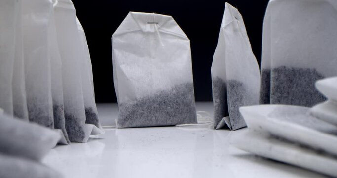 Super close-up set of tea bags on a white table on a black background. Making morning tea. Macro shooting for tea clip is suitable for culinary and culinary projects.