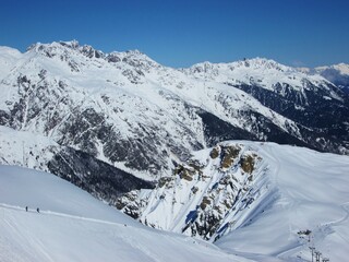 View of mountains and ski slopes in Les Sybelles, France. Snow capped peaks against blue sky. Sunny day in France. Fun during holidays. Ski business.  Saint Sorlin d'Arves. Alps.
