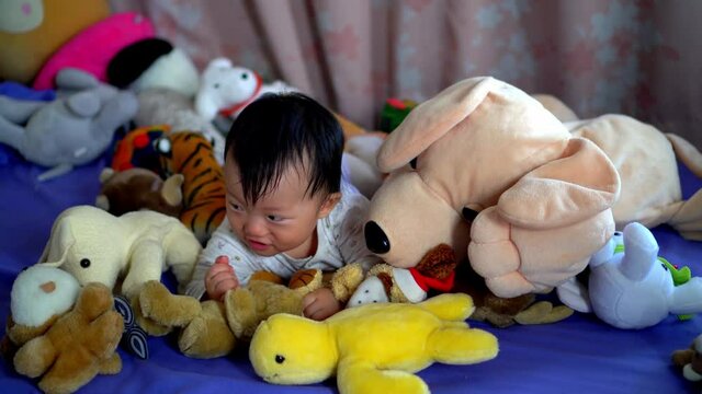 Little baby carry dog plush toy and action in pile of toy