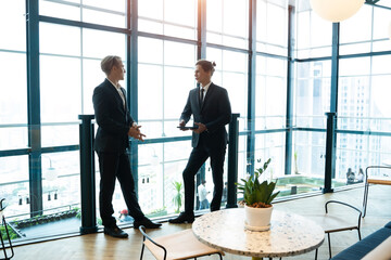 Business partners discussing documents and ideas at meeting and communicating at the office.