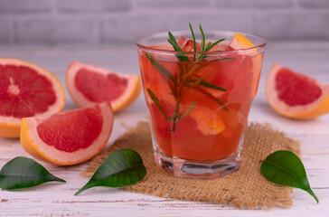 Grapefruit juice in a glass on a white background.	