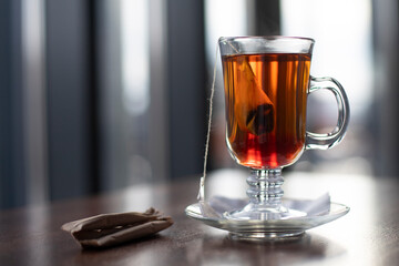 Tea in a glass and sugar bags on a blurred background. Place for an inscription, background for a postcard.