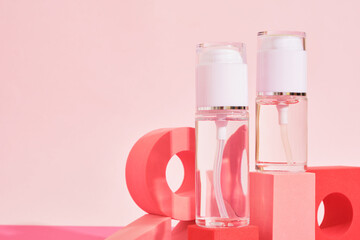 two glass bottles with spray and dispenser on a pink podium on a pink background, bottles for perfume or serum